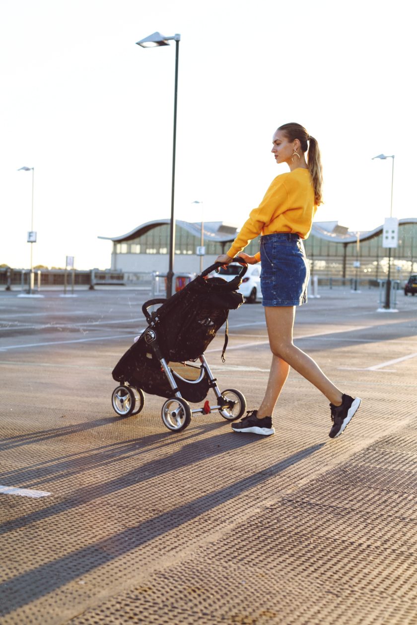 woman holding stroller during daytime